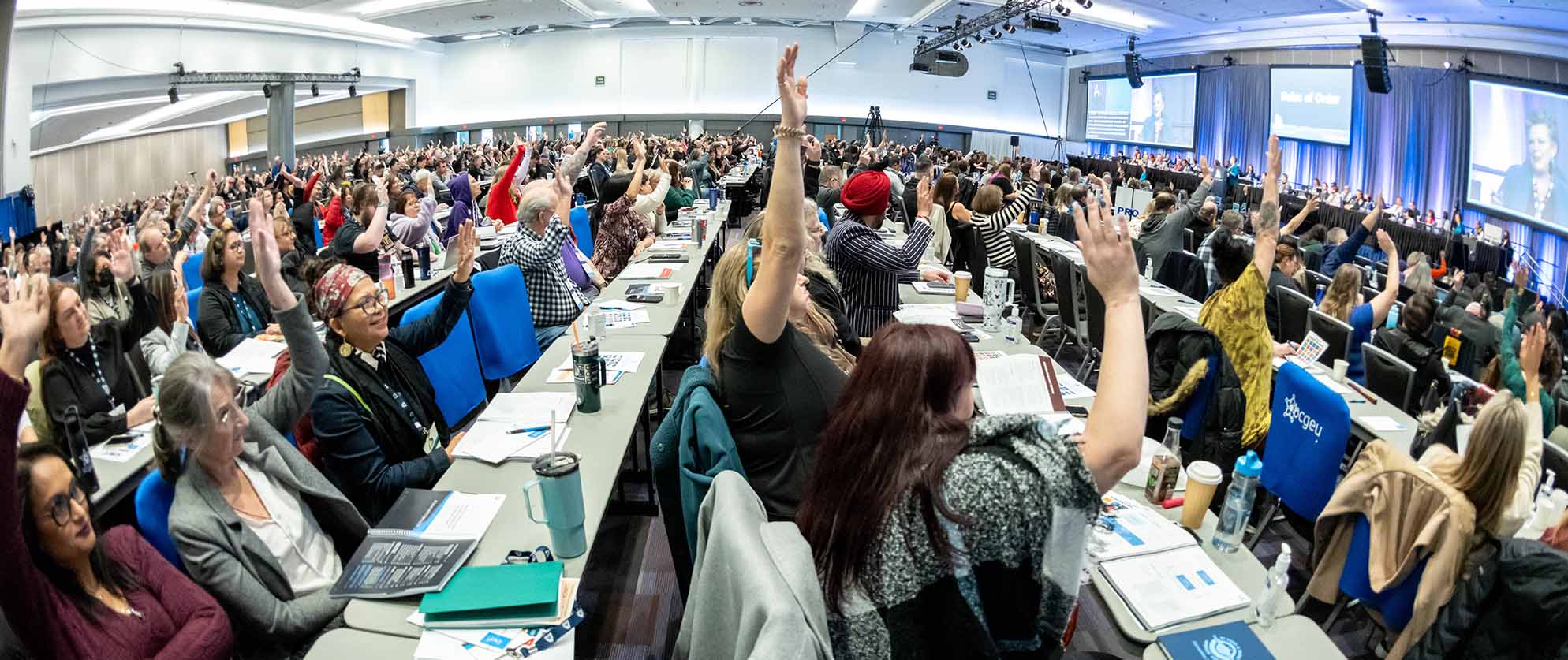 Wide view of the BCFED convention floor, with hundreds of delegates raising their hands